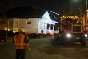A truck eases a Victorian cottage from the lot onto Royal Street during its move to the West Adams/University Park community, Friday, July 24, 2015.