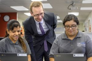 USC Provost Michael Quick, center. talks with prep-school students Kate Alvara, 14, left and Joceline Morales, 14, right, during the opening and dedication of East College Prep in Los Angeles, Tuesday, October 20, 2015.(USC Photo/Gus Ruelas)