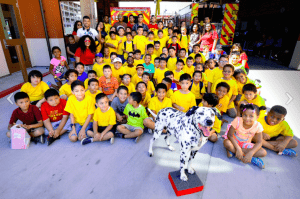 GNC funded program, Kinder2College students pose with Wilshire the fire dog. (USC Photo/Gus Ruelas)