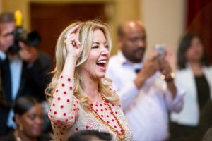 Lakers owner Jeanie Buss shows the victory sign as the USC Marching Band performs at the Neighborhood Academic Initiative Gala at USC, Thursday, May 6, 2016. (Photo by Michael Owen Baker)